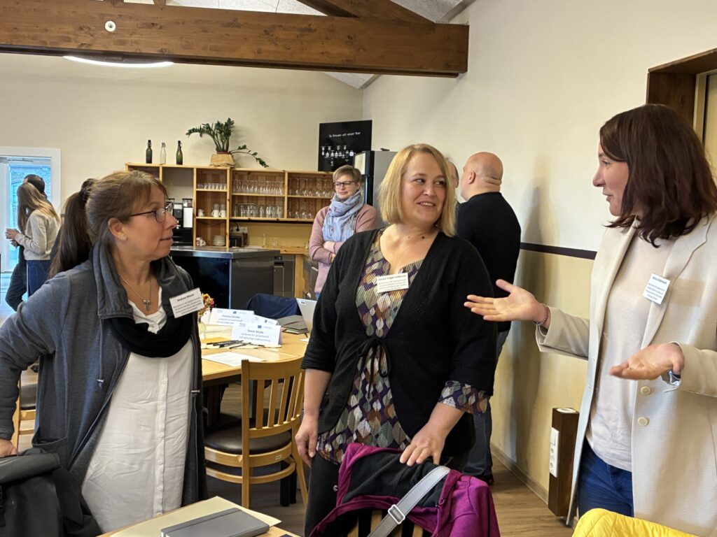 Drei Frauen stehen zusammen und unterhalten sich